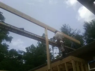 Carpenter setting a ridge beam over a new addition frame — Ice Dam Removal by Roofing Brothers in Woodbury